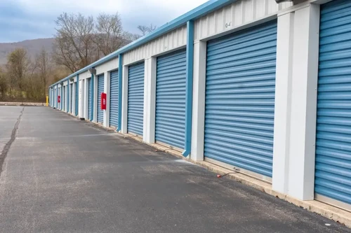 A row of outdoor storage units with blue doors.